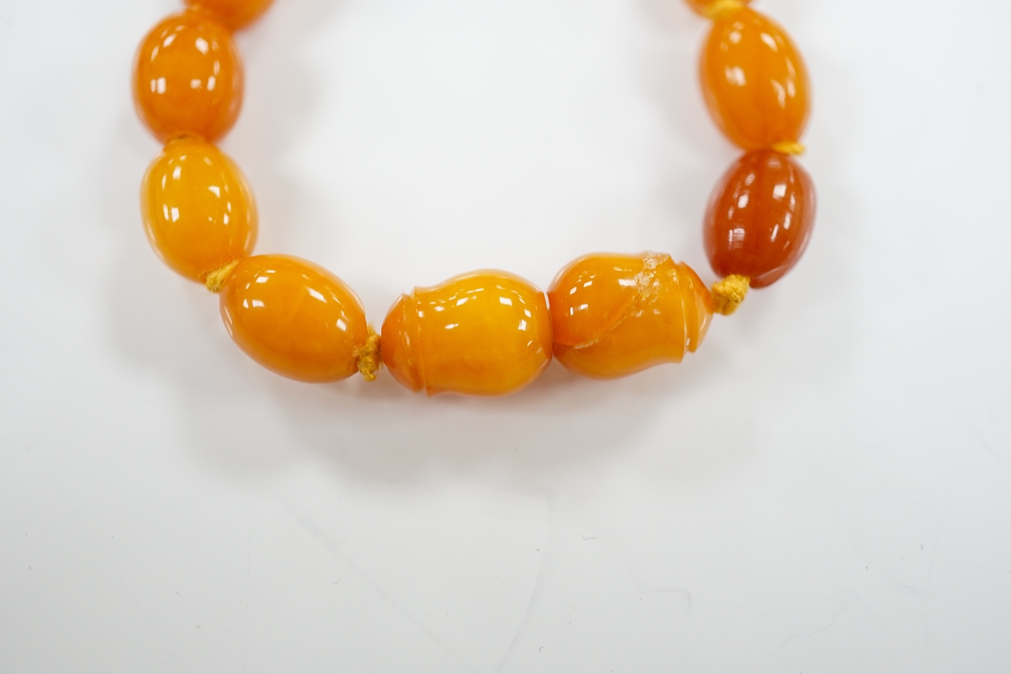 A single strand graduated oval amber bead necklace, 66cm, gross weight 48 grams. Condition - poor to fair